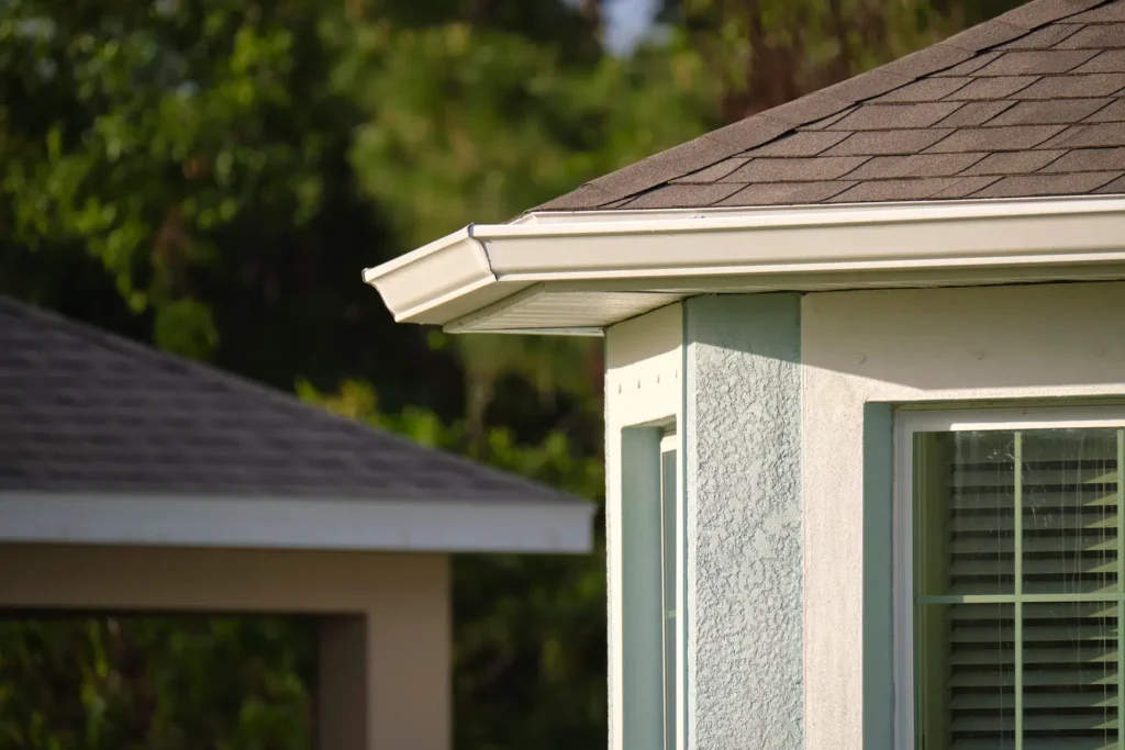 Close-up of a home's roof, gutters, and window.