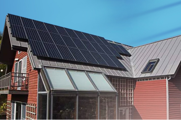 Metal roof with solar panels on a red house. Eco-friendly metal roofing solution.