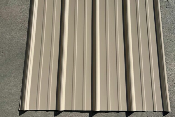 Tan metal roofing panel with vertical ribs, showcasing the material's texture and design.