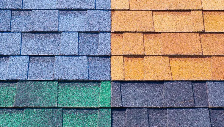 Close-up of asphalt shingles in blue, orange, green, and gray colors.